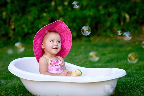 美しい小さな女の子が降り注ぐ夏ピンク帽子 — ストック写真