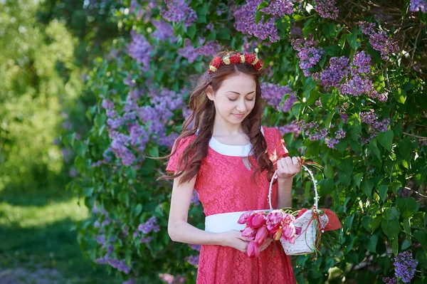 Bela mulher com um buquê de lilás no parque da primavera — Fotografia de Stock