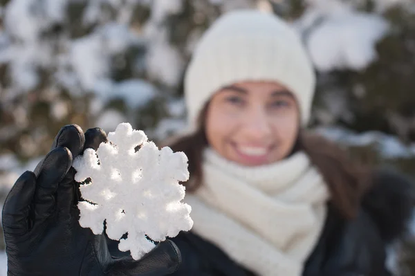 Menina bonita segurando um floco de neve de inverno — Fotografia de Stock