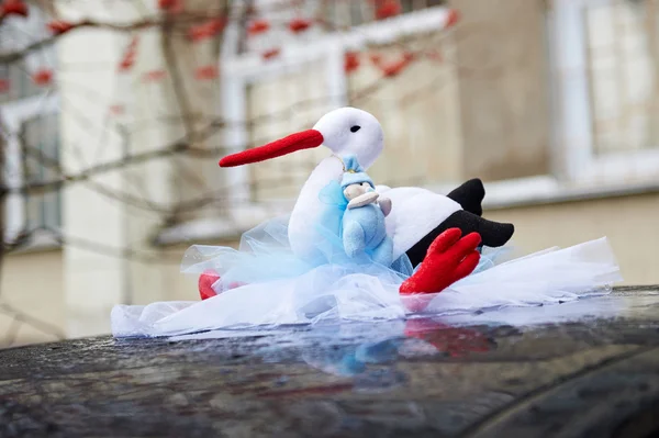 Stork föra baby på taket av bilen — Stockfoto