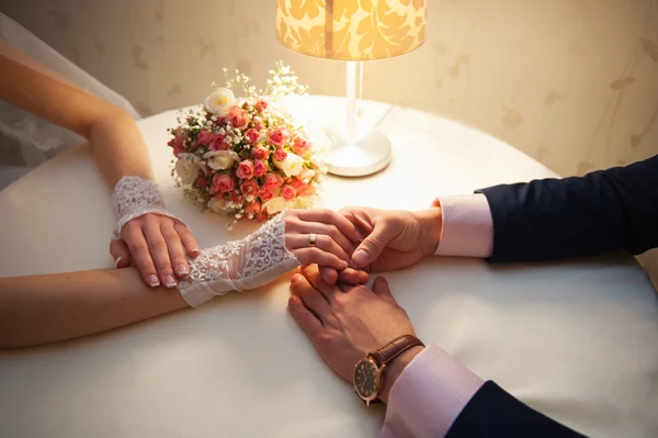 Sposo tiene la mano della sposa a tavola — Foto Stock