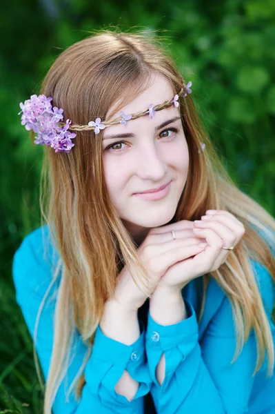 Portrait d'une belle jeune femme avec une couronne dans le parc du printemps — Photo