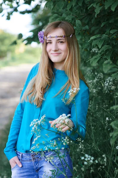 Portrait d'une belle jeune femme avec une couronne dans le parc du printemps — Photo