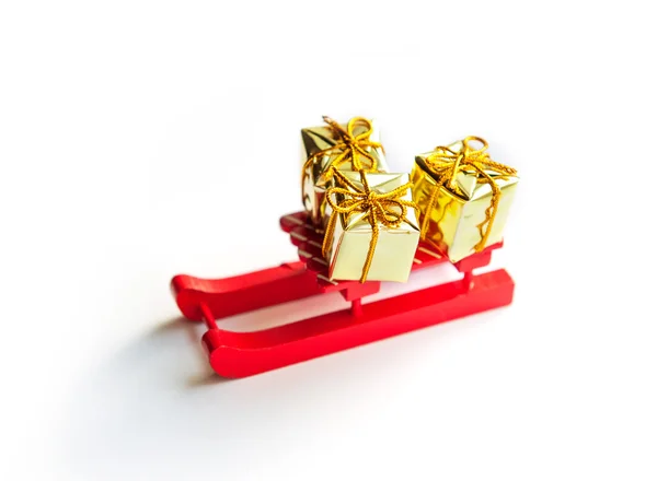 Juguete de madera trineo con regalos de Navidad sobre fondo brillante — Foto de Stock