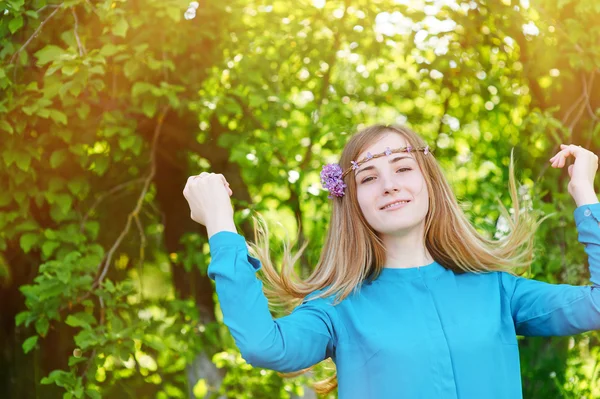 Porträt einer schönen jungen Frau mit Kranz im Frühlingspark — Stockfoto