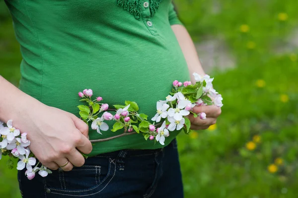 Mujer embarazada hermosa en el jardín floreciente —  Fotos de Stock