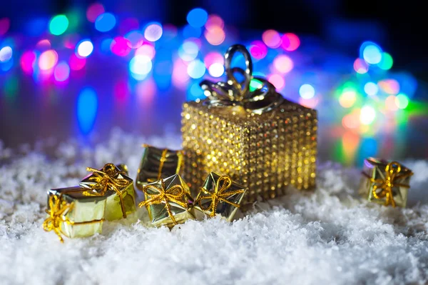 Boże Narodzenie obecny w Złotym opakowaniu z taśmy na zimowe tło — Zdjęcie stockowe