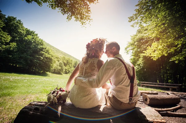 时尚的婚礼夫妻坐在公园的长椅上 — 图库照片