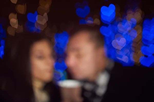 Ζευγάρι στο πόσιμο latte σε φόντο μπλε καρδιές αγάπη — Φωτογραφία Αρχείου