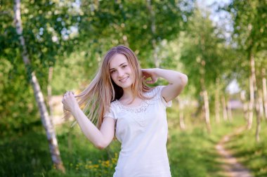 güzel kadın yaz günü huş Grove çimenlerin üzerinde yürüyüş