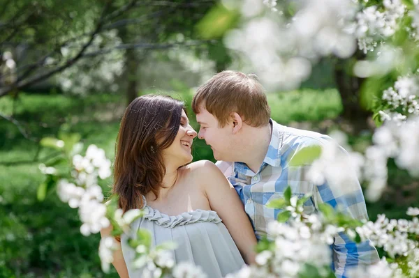 Giovane coppia innamorata passeggiando nel giardino fiorito primaverile — Foto Stock