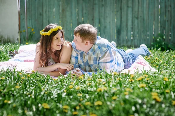 Casal amoroso no jardim da primavera em um cobertor de piquenique para mentir — Fotografia de Stock