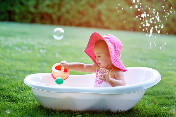 Bambina seduta in una vasca da bagno con bolle di sapone — Foto Stock