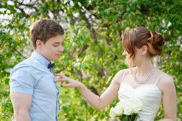 Bride flirting with groom on a walk in spring garden — Stock Photo, Image