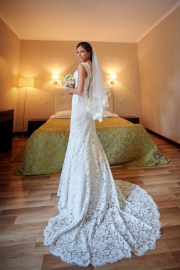 El, bir buket ile güzel gelin düğün günü odada poz