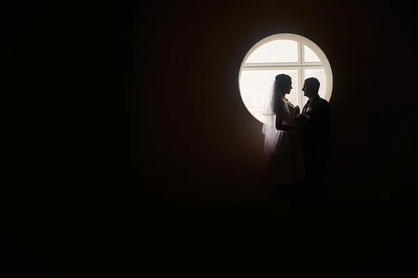 Σιλουέτα νύφης και γαμπρού στο φόντο του παραθύρου — Φωτογραφία Αρχείου