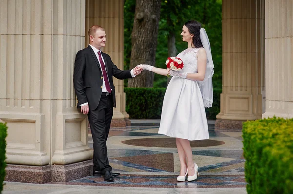 Lyckliga bruden och brudgummen promenader i en sommar park — Stockfoto