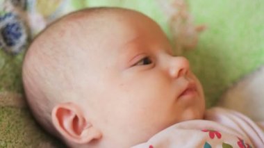 yatakta yatan küçük bebek kız gülümseyerek