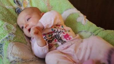 yatakta yatan küçük bebek kız gülümseyerek