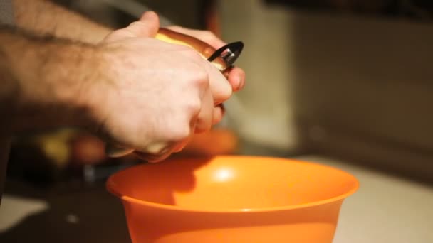 Homem descascando batatas na cozinha para preparar comida — Vídeo de Stock