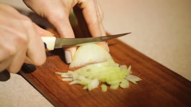 Mujer corta cebolla en el cuchillo de cocina en una tabla de cortar — Vídeos de Stock