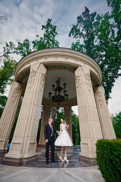 Mariée et marié marchant dans le parc d'été en plein air avec l'architecture — Photo