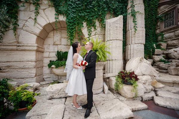 Mariée et marié marchant dans le parc d'été en plein air avec l'architecture — Photo