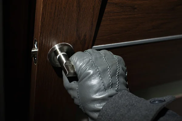 Die Hand eines Mannes in einem schwarzen Handschuh, der die Tür öffnet — Stockfoto