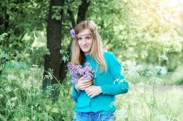 Porträt einer schönen jungen Frau mit Kranz im Frühlingspark — Stockfoto