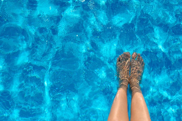 Pernas femininas na água da piscina no verão — Fotografia de Stock