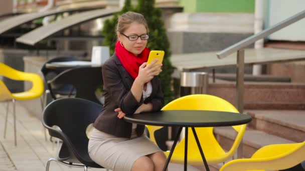 在桌子上看着智能手机的一家咖啡馆的女商人 — 图库视频影像