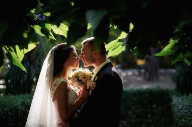 Gelin ve damat ile yaz parkta yürüyen bir buket