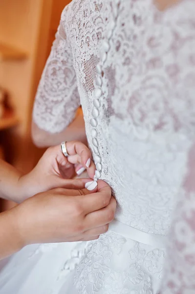 Demoiselles d'honneur aidant la mariée à porter une robe de mariée — Photo