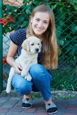 güzel sarışın kadın beyaz bir Labrador köpek yavrusu ile oynamak