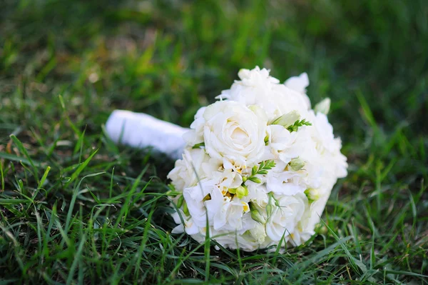 Beautiful bridal wedding bouquet lying on the grass — Stock Photo, Image