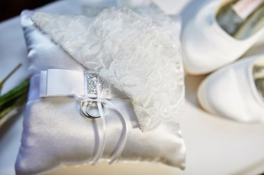 Alyans bir yastık ve gelinin beyaz ayakkabı
