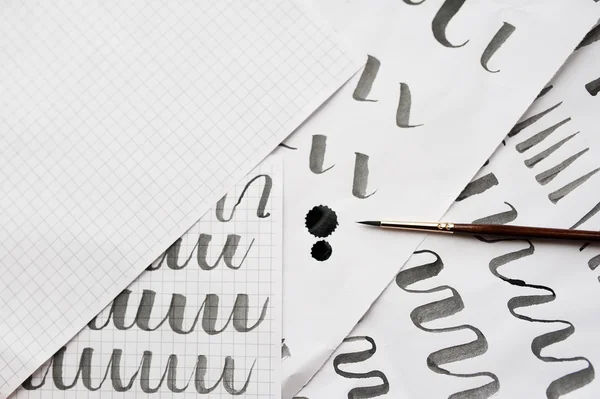 Apprentissage de la calligraphie - papier avec exemple et pinceau et encre — Photo
