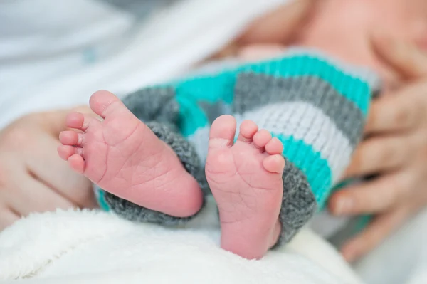 Infant's small feet closeup with mother hands — Stock Photo, Image