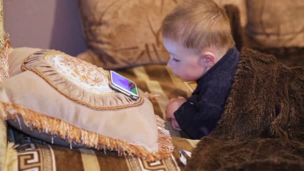 Piccolo ragazzo guardando cartone animato a uno smartphone — Video Stock