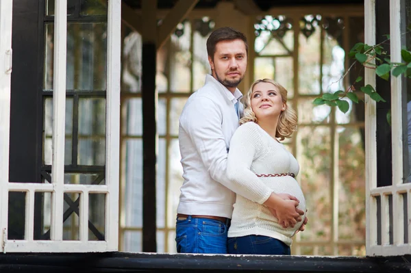 Man met zijn zwangere vrouw op de veranda van het huis — Stockfoto