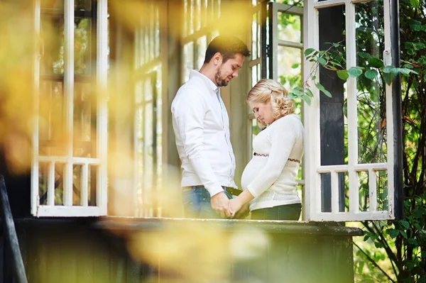 Husband with his pregnant wife on the porch of the house — Stock Photo, Image