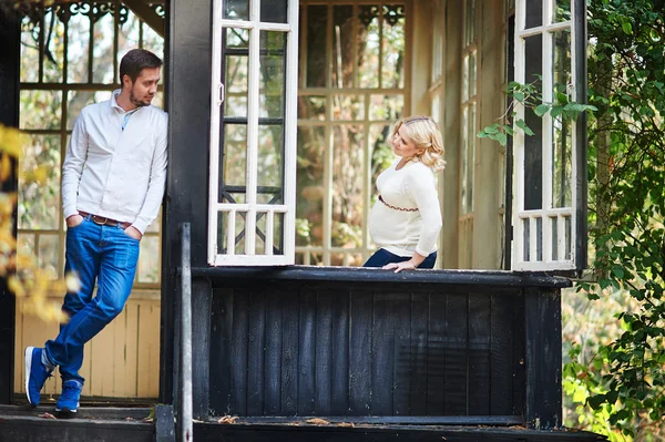 Husband with his pregnant wife on the porch of the house — Stock Photo, Image