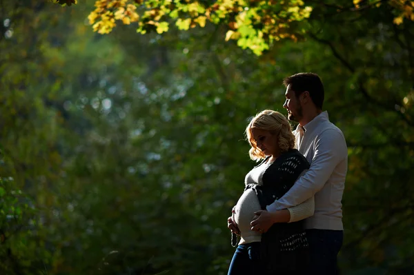 Man en zwangere vrouw lopen in het park — Stockfoto