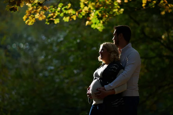 Mari et femme enceinte marchent dans le parc — Photo