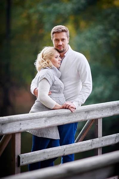 Joven rubia con su marido en el parque en el puente —  Fotos de Stock