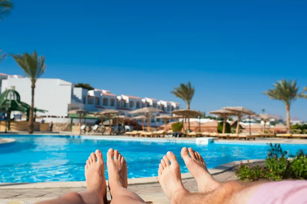 Man and woman sunbathing by the pool at the hotel