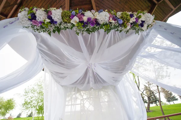 Vackra bröllop arch för ceremonin av blommor i sommar park — Stockfoto