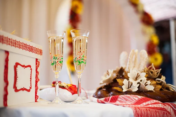 Dois copos com champanhe e pão de casamento na mesa — Fotografia de Stock