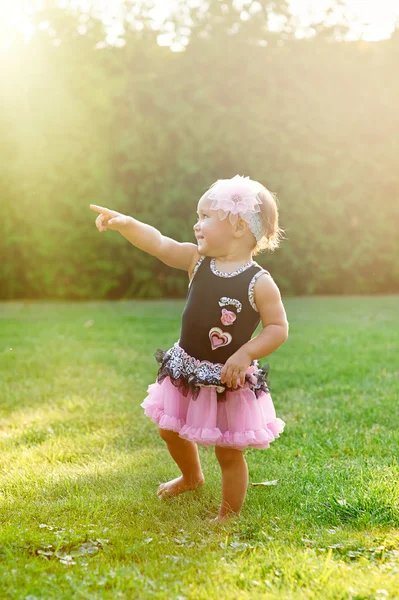 Fröhliches kleines Mädchen spielt auf der Sommerwiese im Gras — Stockfoto