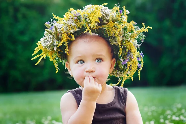 Beautiful happy little baby girl in a wreath on a meadow on the nature — Stock Photo, Image